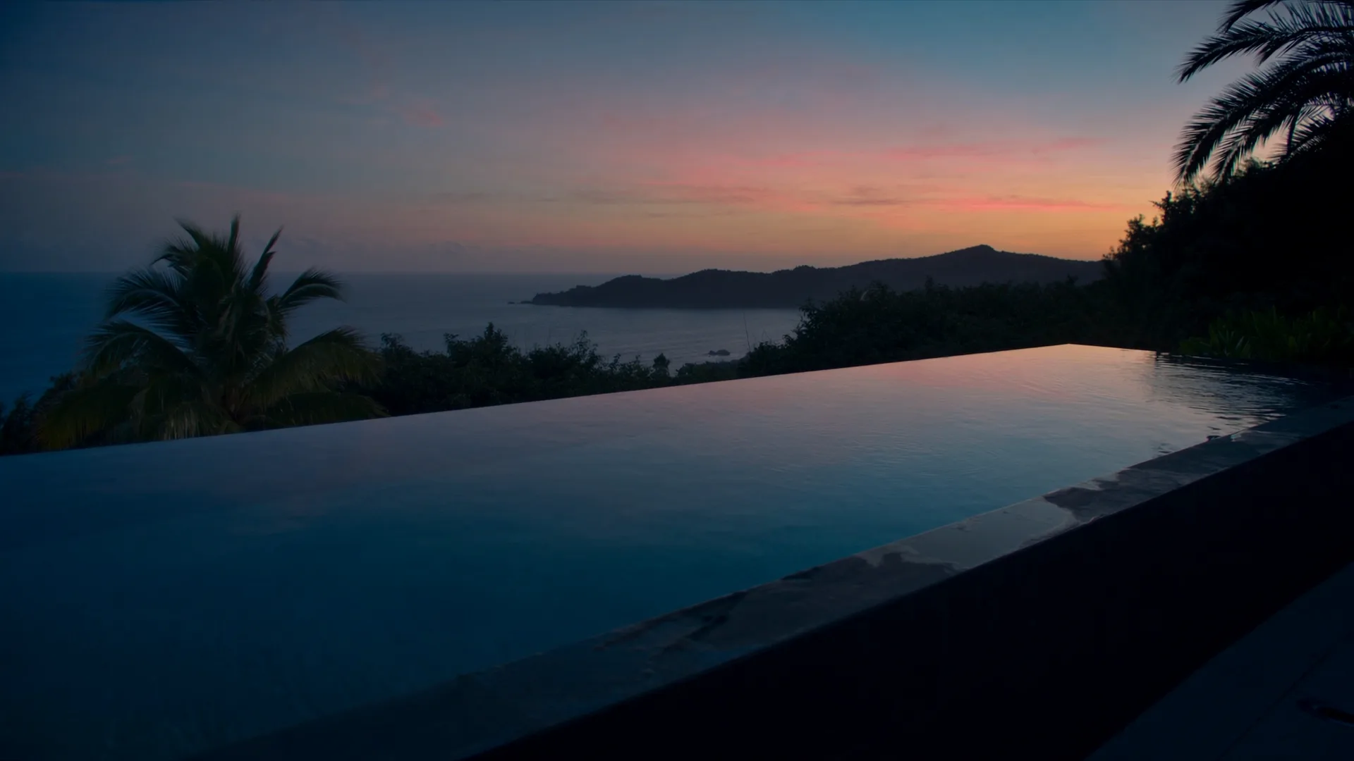 Piscina infinita de una villa al caer la tarde sobre el Pacífico